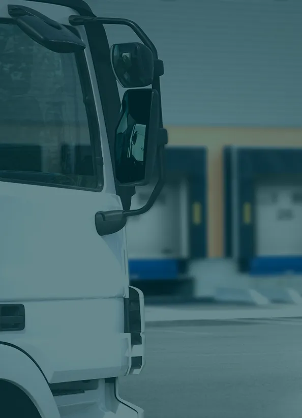 Detail view of a truck parked near a loading dock at a warehouse facility